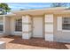 Inviting front entrance with brick flooring, painted columns, screen door, and windows on either side, offers curb appeal at 8116 Parrot Dr, Orlando, FL 32825