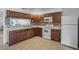 Well-lit kitchen features ample cabinetry, tile backsplash, white appliances, and tile flooring for a clean look at 8116 Parrot Dr, Orlando, FL 32825