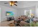 Cozy living room featuring tile floors, comfortable seating, a ceiling fan, and a mounted TV for modern living at 8116 Parrot Dr, Orlando, FL 32825