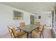 An indoor view of the screened porch with a table set and white-washed walls, offering a cozy outdoor living space at 8116 Parrot Dr, Orlando, FL 32825