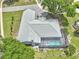 An aerial view of a home with a pool and screened enclosure, surrounded by lush landscaping and a grey tile roof at 8248 Marbella View Ct, Orlando, FL 32817