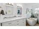 Elegant bathroom with double sinks, marble countertops, decorative mirrors, and a modern freestanding tub at 8248 Marbella View Ct, Orlando, FL 32817