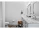 Bright white bathroom featuring double vanity with marble countertop, a toilet, and stylish design at 8248 Marbella View Ct, Orlando, FL 32817