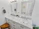 Bathroom featuring double sinks with granite countertops, white cabinetry, and mosaic-framed mirrors at 8248 Marbella View Ct, Orlando, FL 32817