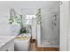 Bright bathroom featuring a soaking tub, walk-in shower, white cabinets, and natural light, enhanced by plants at 8248 Marbella View Ct, Orlando, FL 32817