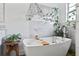 Modern white bathtub complemented by elegant fixtures and green plants, creating a spa-like experience at 8248 Marbella View Ct, Orlando, FL 32817