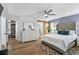Bright bedroom featuring hardwood floors, a ceiling fan, a closet and an ensuite bathroom at 8248 Marbella View Ct, Orlando, FL 32817