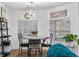 Bright dining area featuring a modern chandelier, round marble table, and natural light from the windows at 8248 Marbella View Ct, Orlando, FL 32817