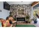 Enclosed lanai with stone feature wall, electric fireplace, and cozy seating at 8248 Marbella View Ct, Orlando, FL 32817