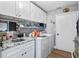 Functional laundry room boasts granite countertops, stainless sink, and white cabinetry at 8248 Marbella View Ct, Orlando, FL 32817