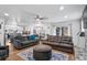Open concept living room with a modern kitchen, dining area, and stone fireplace at 8248 Marbella View Ct, Orlando, FL 32817