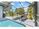 Gorgeous pool with lounge seating and tropical plants, all within a screened enclosure at 8248 Marbella View Ct, Orlando, FL 32817