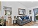 Sitting room with wood-look floors, a comfortable couch, and view into the main bedroom at 8248 Marbella View Ct, Orlando, FL 32817