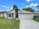 Well-maintained single-story home with a two-car garage and a green lawn at 826 Long Bay Ct, Kissimmee, FL 34741