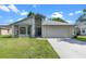 Charming single-story home featuring a well-manicured lawn and a two-car garage at 826 Long Bay Ct, Kissimmee, FL 34741