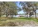 Community waterfront with a dock and mature trees providing shade and a bench for relaxing at 8308 Granada Blvd, Orlando, FL 32836