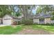 Charming single-story home featuring a lush green lawn and mature trees providing ample shade at 8308 Granada Blvd, Orlando, FL 32836