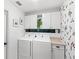 Laundry room with white cabinets, modern washer and dryer set, and neutral counters at 8308 Granada Blvd, Orlando, FL 32836