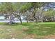 Community playground with mature trees providing shade and a lake view in the background at 8308 Granada Blvd, Orlando, FL 32836