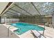In-ground pool surrounded by screened enclosure, lush greenery, and lounge furniture at 8308 Granada Blvd, Orlando, FL 32836