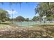 Community tennis court with a green playing surface and a view of the lake and playground at 8308 Granada Blvd, Orlando, FL 32836