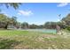 Community tennis court with a green playing surface and mature trees in the background at 8308 Granada Blvd, Orlando, FL 32836