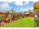 Lush backyard featuring green lawn, decorative fence, and colorful landscaping elements at 887 Reedy Cv, Casselberry, FL 32707