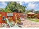 Backyard with a unique fence design, stone patio and lawn area with an outdoor seating at 887 Reedy Cv, Casselberry, FL 32707