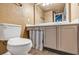Practical bathroom with white toilet, neutral tile floor, vanity and blue and white curtain accent at 887 Reedy Cv, Casselberry, FL 32707