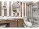 Stylish bathroom featuring a shower, marble countertop, updated vanity, and elegant mirror at 887 Reedy Cv, Casselberry, FL 32707