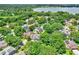Aerial view of the neighborhood lush with mature trees and lake in the background at 991 Hawthorne Cove Ct, Ocoee, FL 34761
