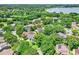 Beautiful aerial view of a neighborhood with lush greenery and a sparkling lake in the background at 991 Hawthorne Cove Ct, Ocoee, FL 34761
