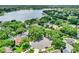 An aerial perspective shows well-kept lawns in a leafy neighborhood near a lake at 991 Hawthorne Cove Ct, Ocoee, FL 34761
