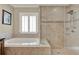 Elegant bathroom features a soaking tub and glass-enclosed shower with neutral-toned tile at 991 Hawthorne Cove Ct, Ocoee, FL 34761