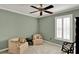 Cozy bedroom featuring twin upholstered armchairs, side table, and shuttered window at 991 Hawthorne Cove Ct, Ocoee, FL 34761