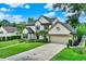 Two-story home with attached garage, landscaped garden, and driveway, offering a blend of comfort and curb appeal at 991 Hawthorne Cove Ct, Ocoee, FL 34761