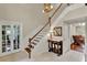 Elegant foyer with staircase, featuring hardwood steps and tiled floor, leading to different living spaces at 991 Hawthorne Cove Ct, Ocoee, FL 34761