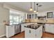 Bright kitchen features stainless appliances, island, black countertops, and white cabinetry at 991 Hawthorne Cove Ct, Ocoee, FL 34761