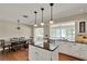 Kitchen boasts a black granite island, stainless appliances, and access to both dining areas at 991 Hawthorne Cove Ct, Ocoee, FL 34761