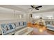Open concept living room with wood flooring, white wicker furniture, blue cushions, and ceiling fan at 991 Hawthorne Cove Ct, Ocoee, FL 34761