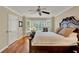 The main bedroom with hardwood floors, ceiling fan, and bay window with decorative shutters at 991 Hawthorne Cove Ct, Ocoee, FL 34761