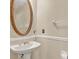 Powder room with pedestal sink, oval mirror with decorative frame, and wall mounted towel bar at 991 Hawthorne Cove Ct, Ocoee, FL 34761