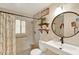 Updated bathroom with a modern sink, decorative shelves, and a shower with a shower curtain at 1000 Sal St, Ocoee, FL 34761