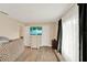 Bright bedroom with wood-look tile flooring, ample natural light, and a TV atop a dresser at 1000 Sal St, Ocoee, FL 34761