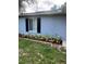 Charming exterior featuring black shutters, well-kept grass, and manicured garden bed at 1000 Sal St, Ocoee, FL 34761