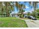 Inviting exterior view of a home with a lush green lawn, mature trees, and a well-lit driveway at 1000 Sal St, Ocoee, FL 34761
