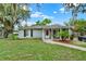 Cozy single-Gathering home featuring a manicured lawn, mature trees, and a charming covered entryway at 1000 Sal St, Ocoee, FL 34761