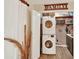 Efficient laundry area with stacked washer and dryer and storage shelves at 1000 Sal St, Ocoee, FL 34761