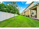 Green backyard featuring a lawn and exterior of a house with a patio area at 10070 Red Eagle Dr, Orlando, FL 32825