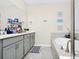 Bathroom with double sink, grey vanity, framed mirror, tub and decor at 10070 Red Eagle Dr, Orlando, FL 32825